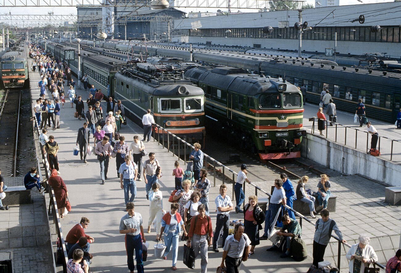 Orang-orang di stasiun kereta api Soviet.