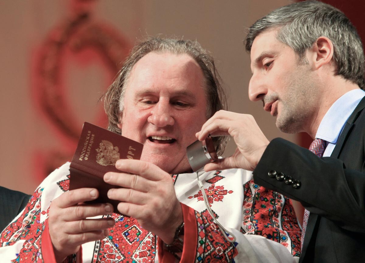 Gérard Depardieu examinant son passeport russe en costume traditionnel mordve avec son traducteur au Théâtre de Saransk, en République de Mordovie, où il avait obtenu un logement