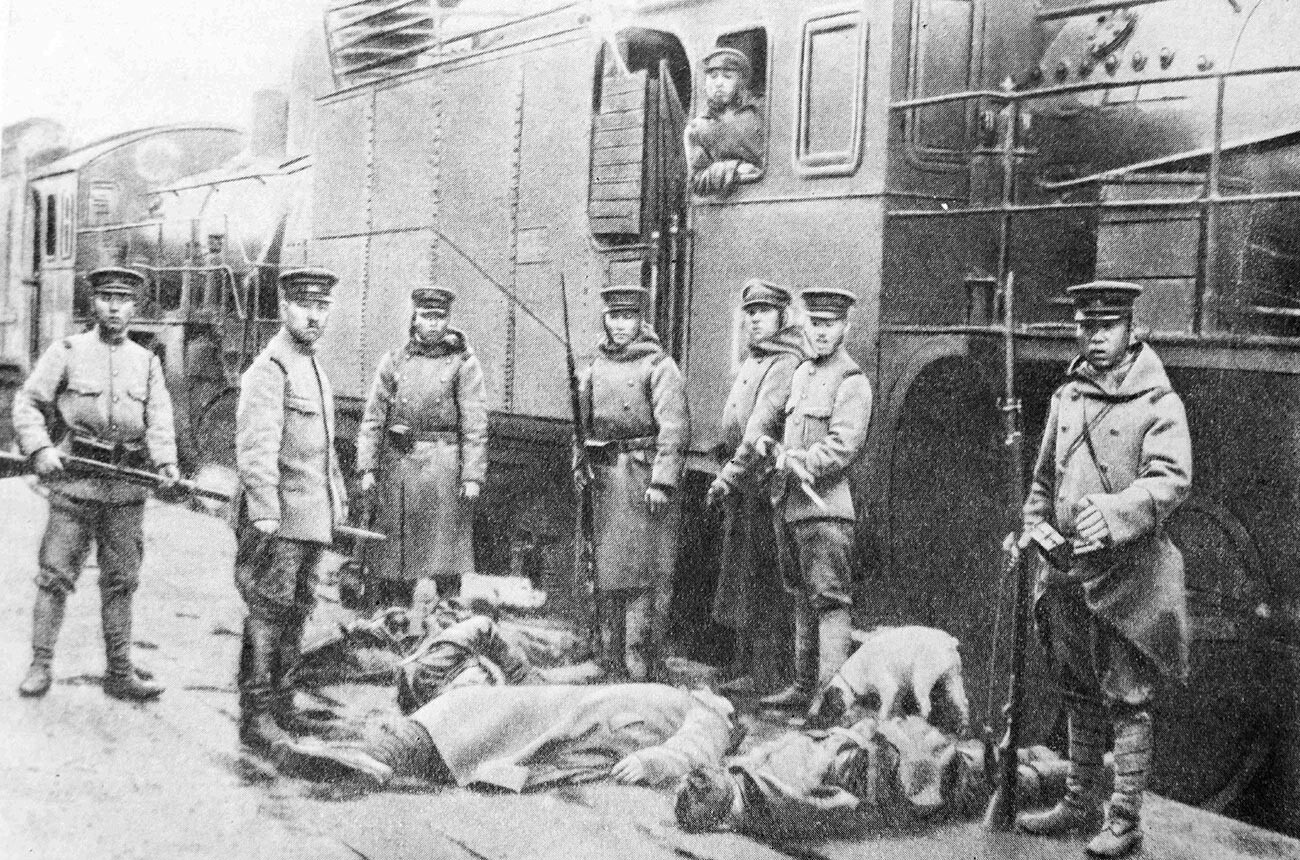 Japanese interventionists standing behind bodies of railway workers executed by them, Russian Far East, 1920.