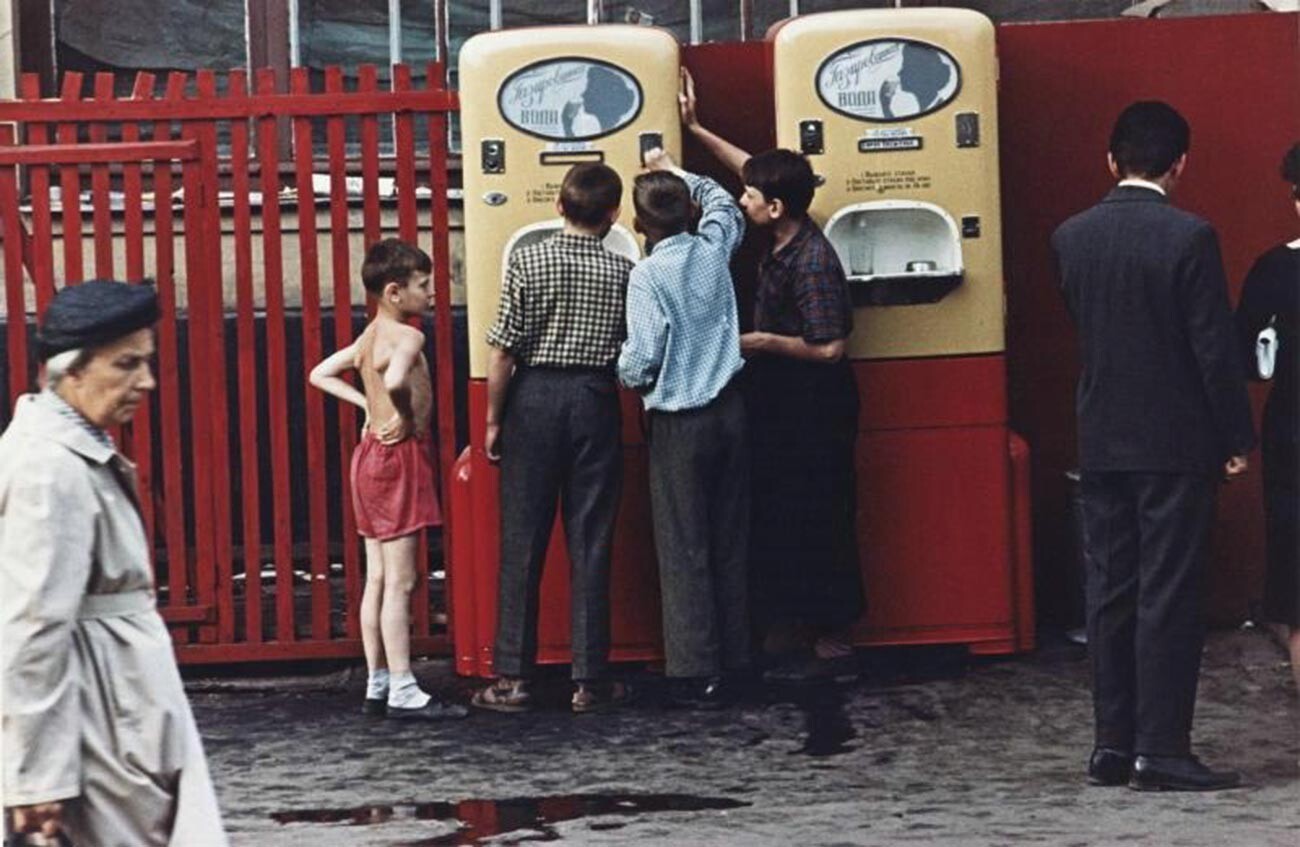 Boys at a vending machine selling soda with syrup.