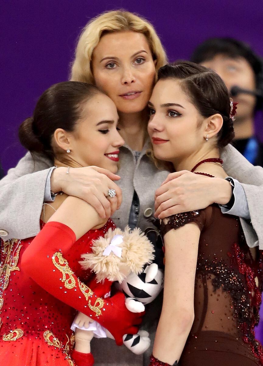 Alina Zagitova (a sinistra, medaglia d'oro) ed Evgenija Medvedeva (a destra, medagli d'argento) festeggiano con Eteri Tutberidze (C) al termine di una gara ai Giochi olimpici invernali di Pyeongchang, 2018