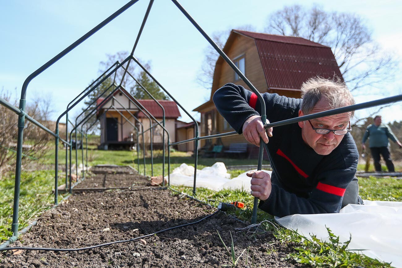 Installation eines Rahmens zum Unterstellen eines Gartenbeets auf einem Grundstück im Dorf Polujewo während der Maiferien.