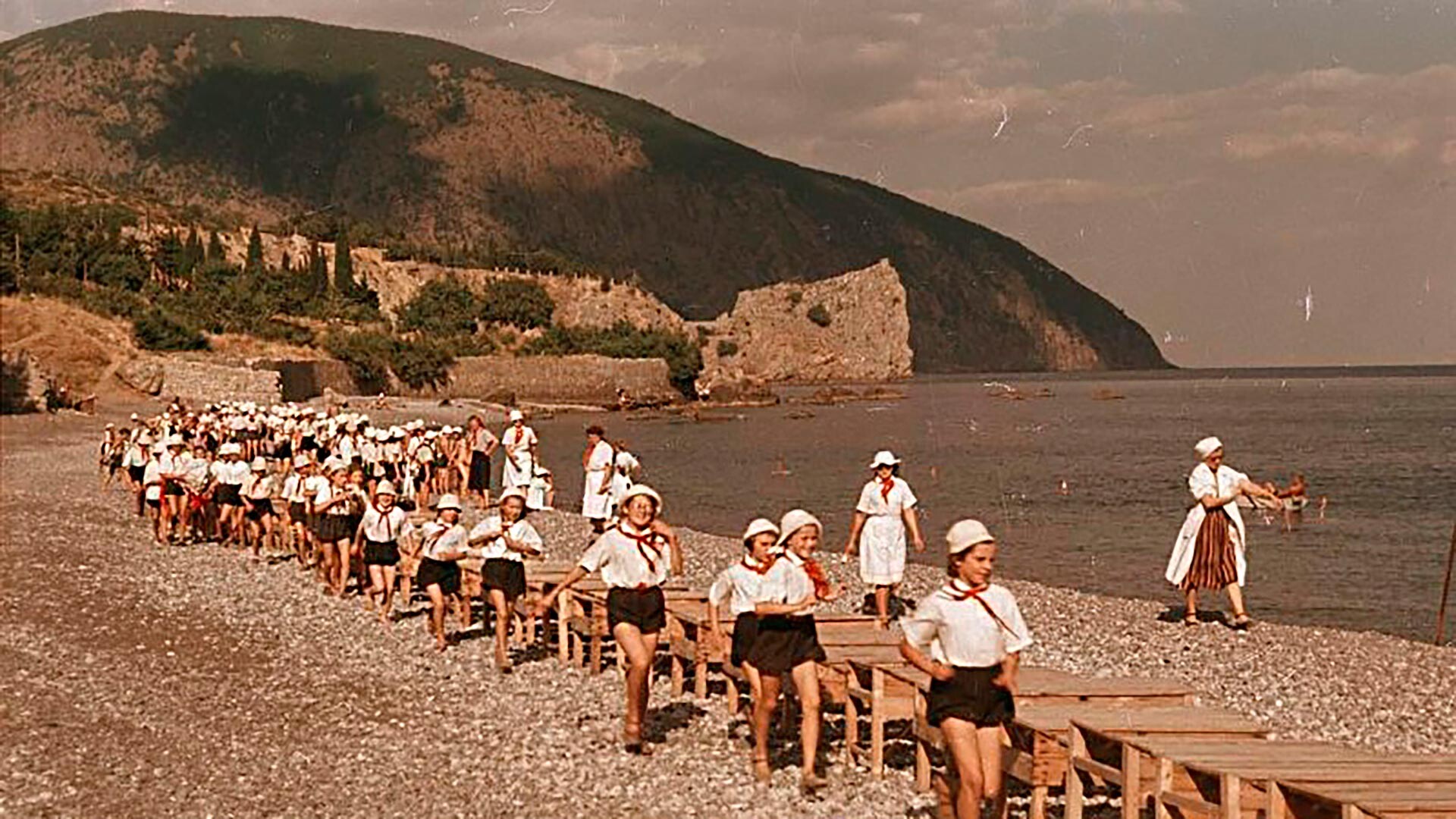 Des enfants du camp de pionniers de Crimée Artek marchant le long de la plage