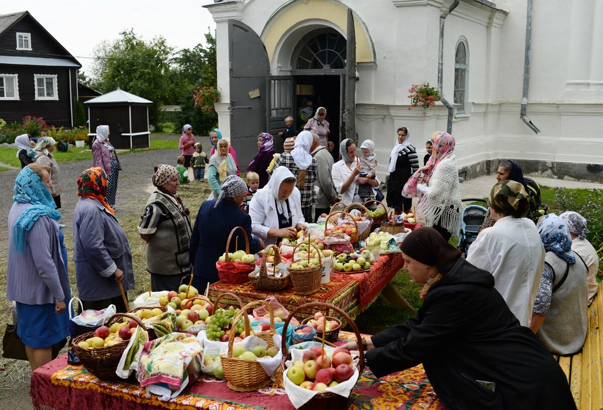 I credenti si preparano a consacrare le mele durante la festa della Trasfigurazione. Chiesa della Trasfigurazione nel villaggio di Bronnitsa, regione di Novgorod