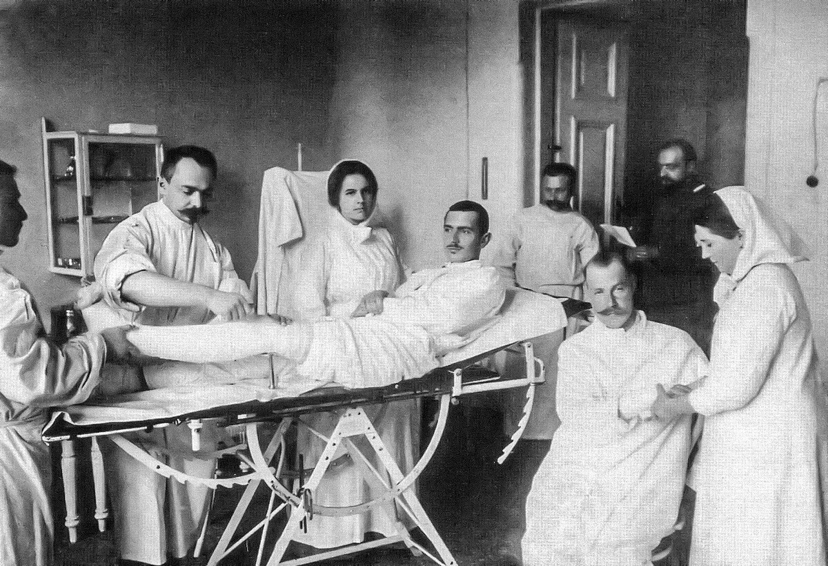Der Arzt I. A. Tichomirow beim Anlegen eines Gipses bei einem Patienten. 