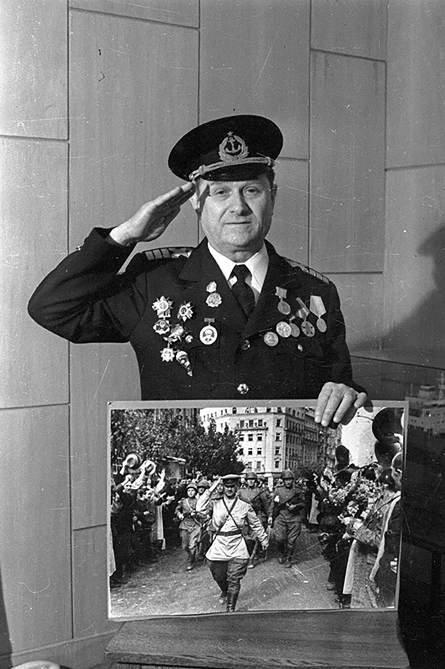 Der Kriegsveteran Dmitri Kudaschew hält hier ein Foto aus der Kriegszeit, das ihn beim Einzug in das befreite Belgrad im September 1945 zeigt (Foto – 1965).
