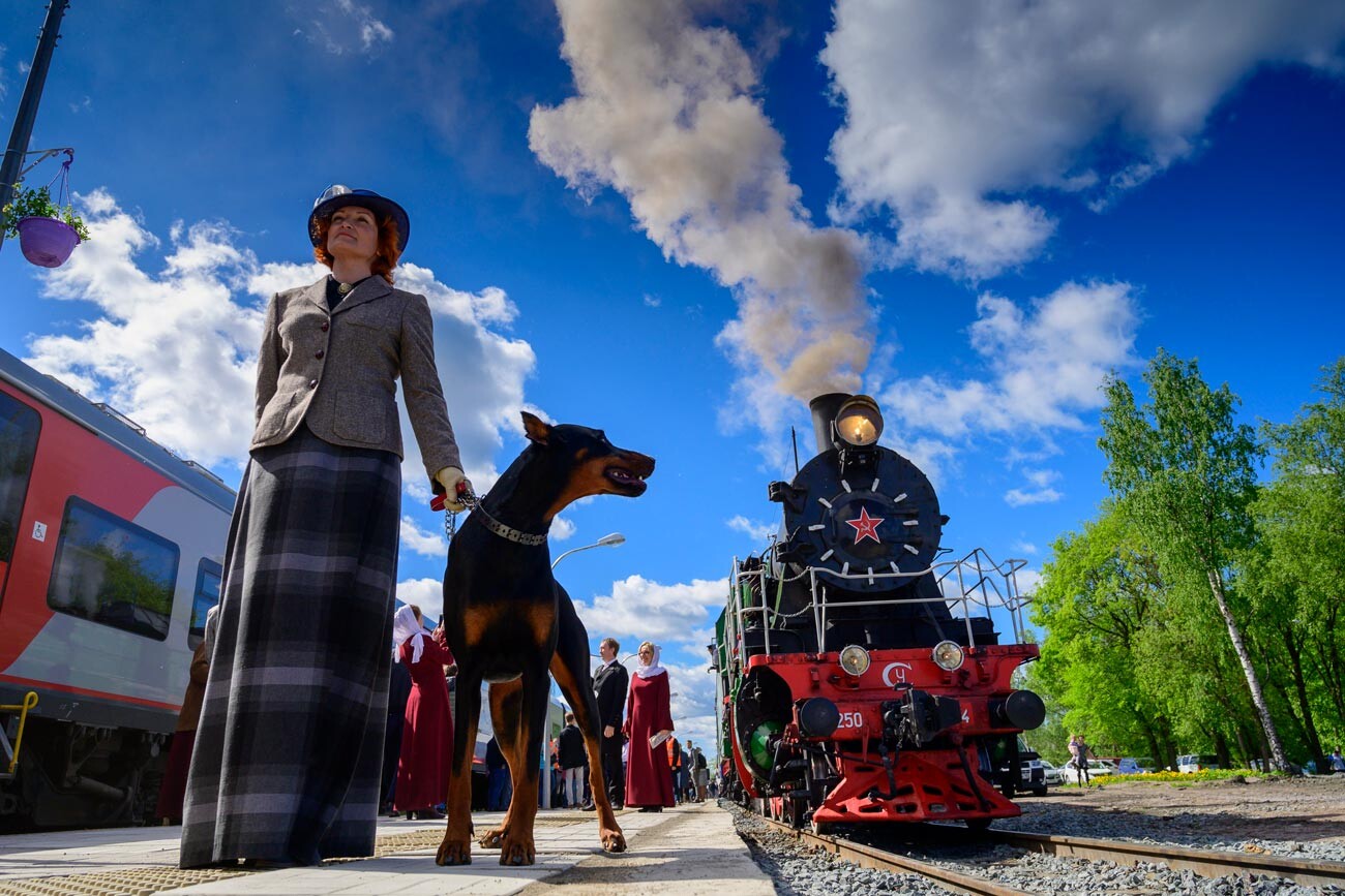Una donna in abito d'epoca vicino al treno espresso Sortavala-Ruskeala