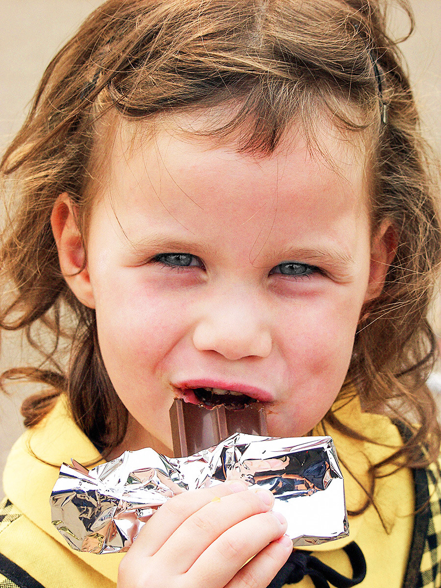 Ein glückliches Kind, das Schokolade isst. 