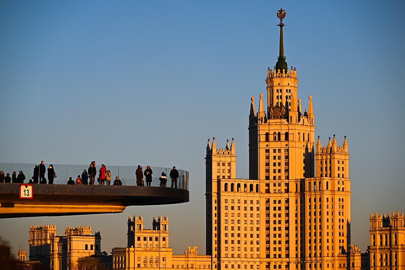 Obiskovalci na lebedečem mostu v parku Zarjadje v Moskvi. 
