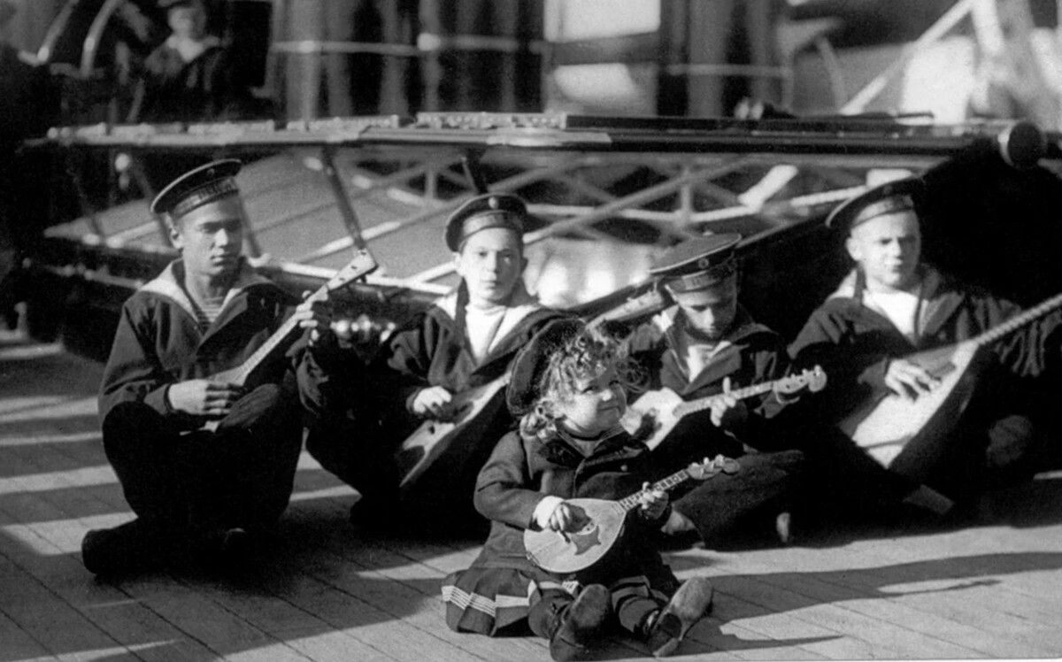 Tsarevich Aleksey (center) holding a balalaika. 