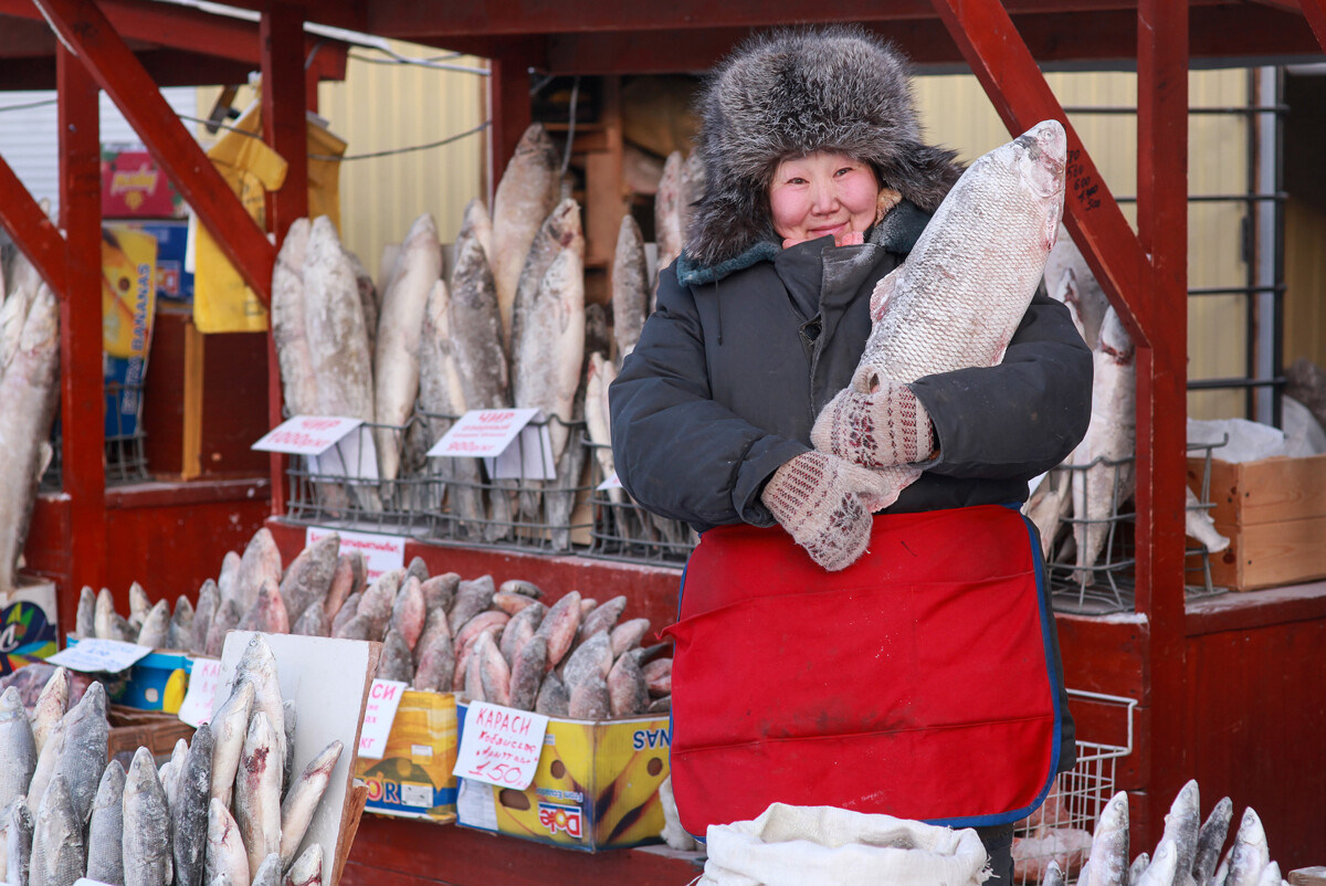 Ein Verkäufer verkauft Fisch auf dem Bauernmarkt bei 30 Grad Frost.
