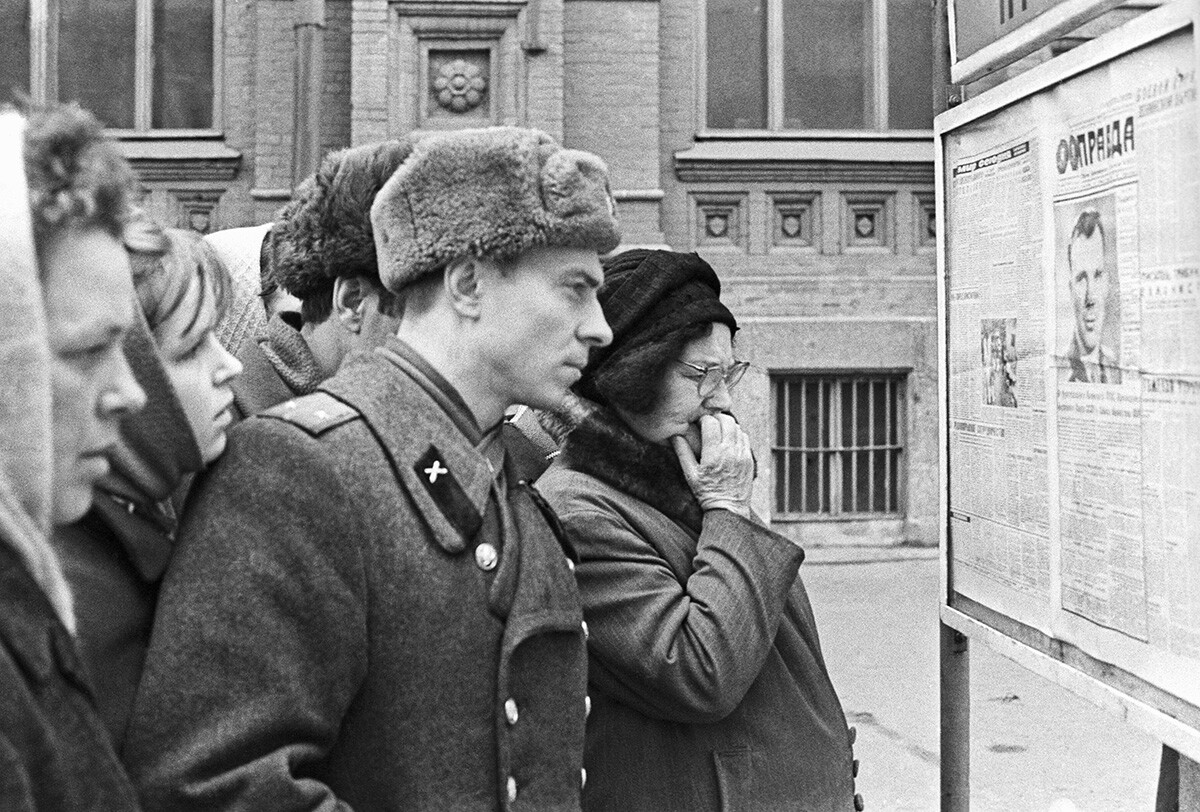 Warga kota membaca berita di surat kabar Pravda tentang kematian tragis Yuri Gagarin dan Vladimir Seregin.