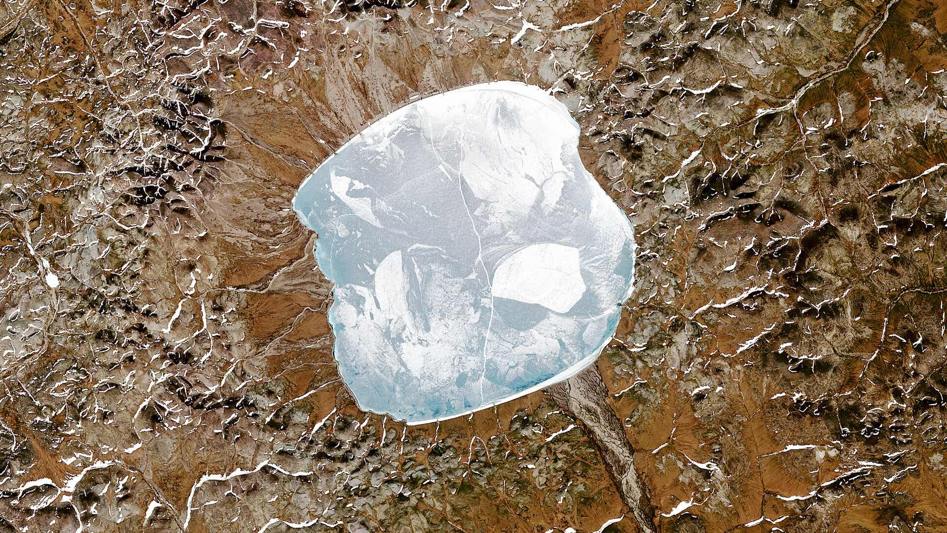 Satelitski posnetek jezera Elgigitgin, ki se nahaja znotraj majhnega kraterja po trku asteroida na vzhodu Rusije blizu polarnega kroga, 20. junija 2015. Udarni krater je star približno 3,6 milijona let.