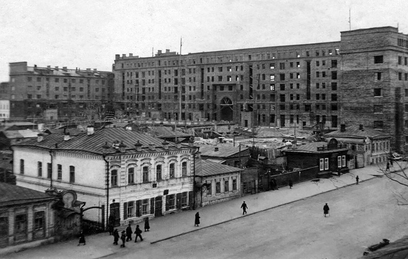 Gradnja 7-nadstropnega stanovanjskega bloka. Glavna fasada stavbe je obrnjena proti Trgu revolucije. Gradnja stavbe se je začela leta 1934, v obratovanje pa je bil uvedena leta 1938. Fotografija pa je bila posneta s strani ulice Kirov. 