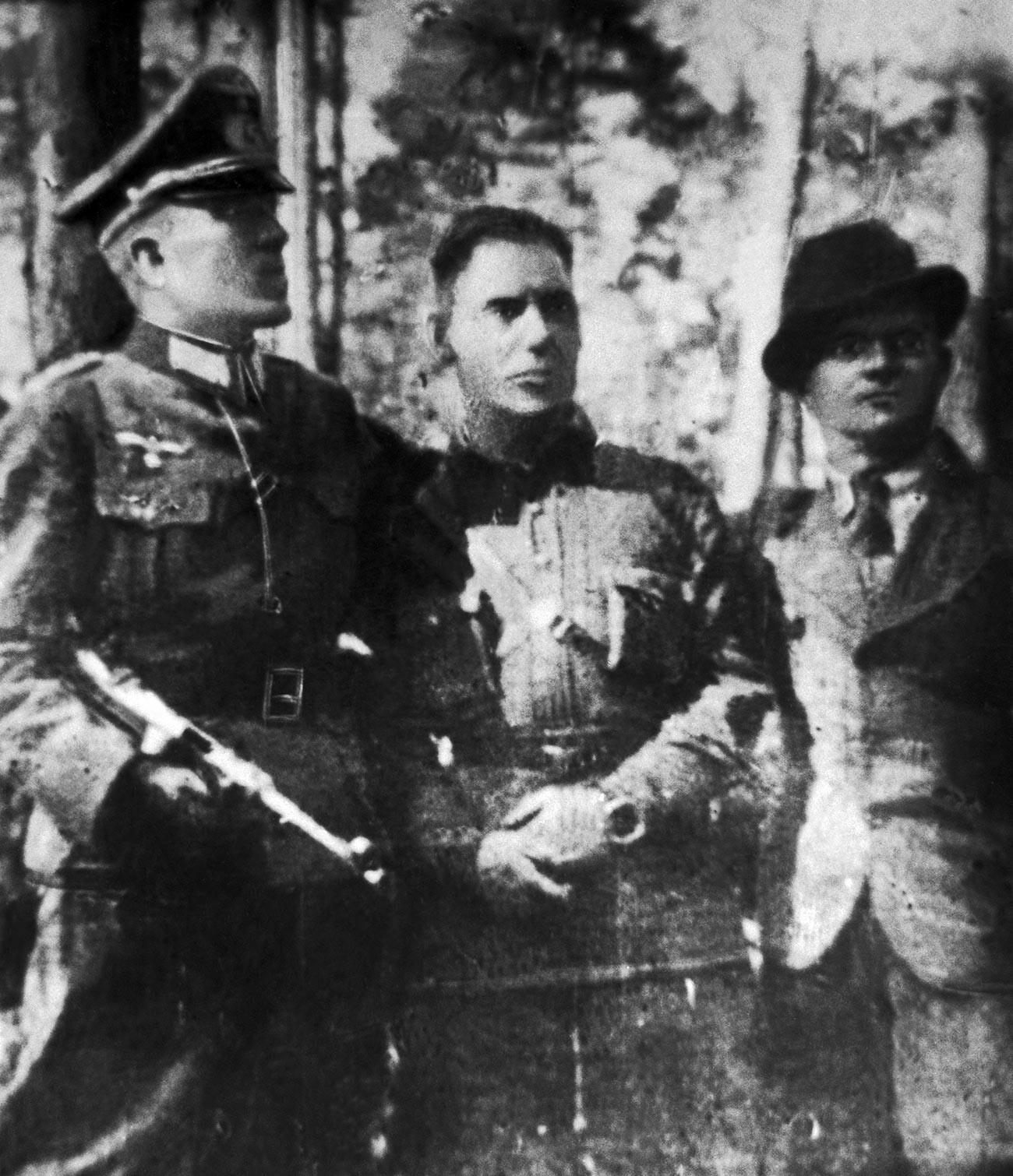 Nikolai Kuznetsov berseragam perwira Jerman (kiri) dengan komisaris dari detasemen partisan Stekhov dan Gnidyuk.
