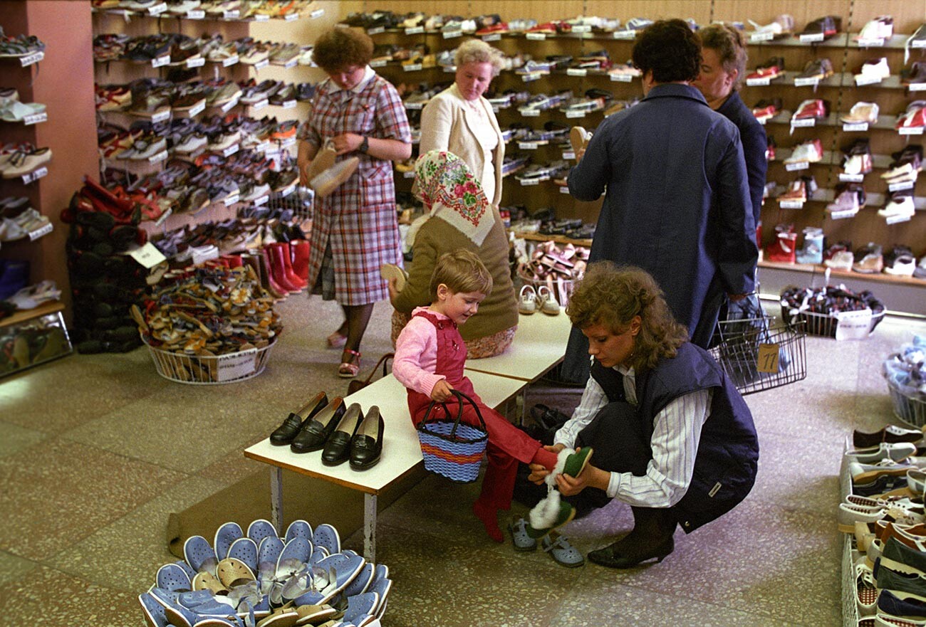 Una donna con la figlia in un negozio di scarpe nella città di Sovetsk, regione di Kaliningrad, 1988