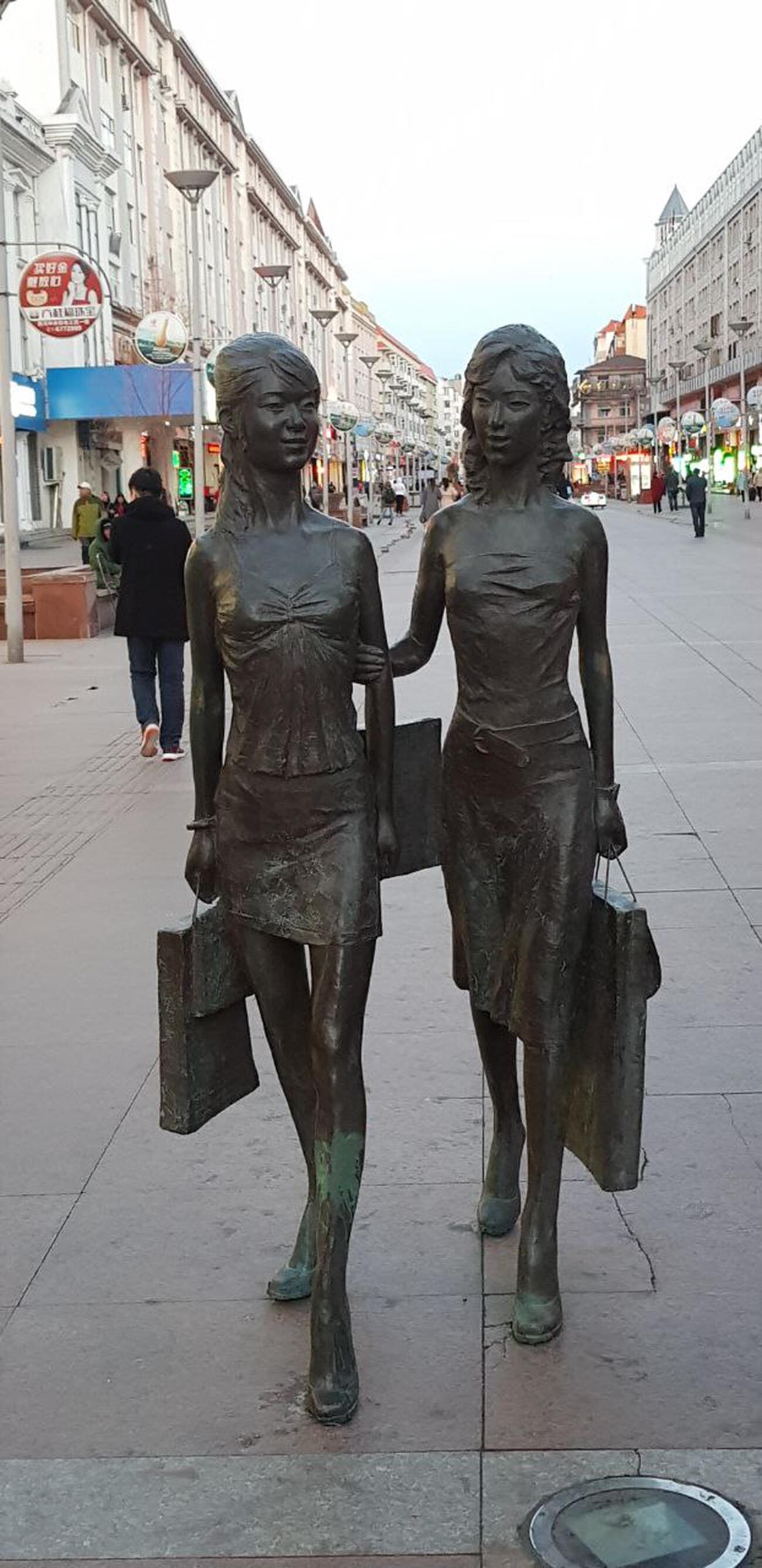 Due ragazze fanno shopping, monumento nella città di Heihe, nell'estremo nord-est della Cina 
