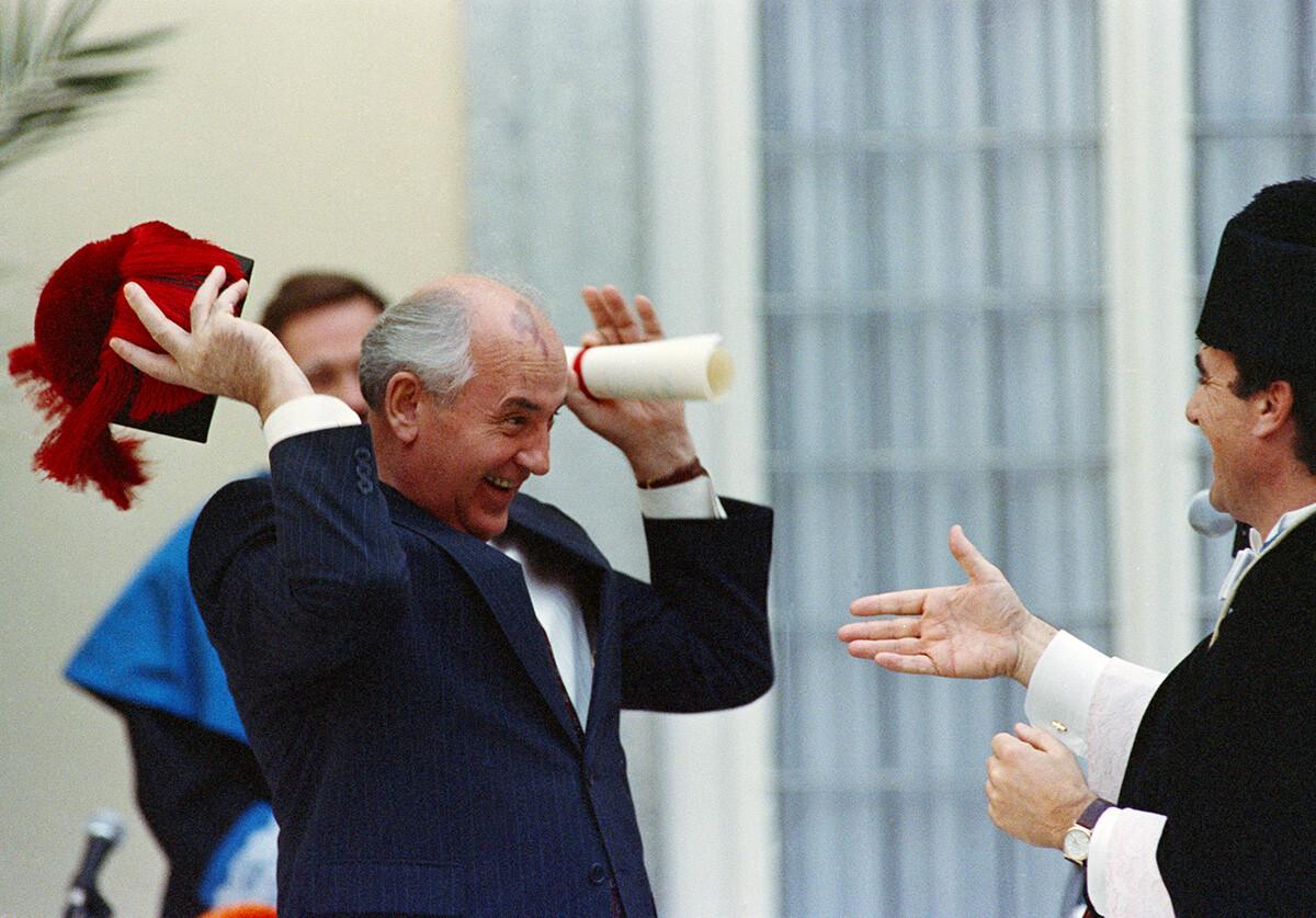 マドリードの2つの大学から名誉学位を得た式典で中世の帽子を取るミハイル・ゴルバチョフ、1990年。ソ連指導者は職員に対し、帽子は鏡で見栄えを確認するまで脱いでおきたいと話したという。