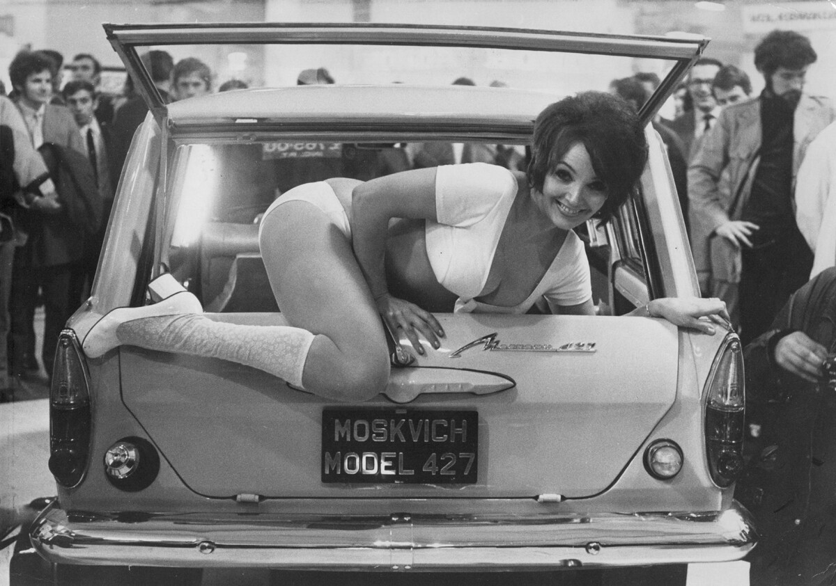 Okoli leta 1971: Julie Desmond, pomanjkljivo oblečena 24-letna manekenka, na avtomobilskem sejmu pleza z zadnjega sedeža ruskega avtomobila Moskvič 427. 
