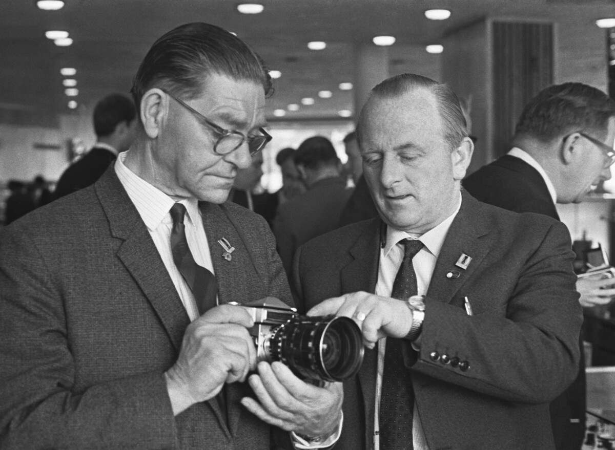 Alcuni businessman britannici osservano la macchina fotografica Zenit-6. Mosca, 1968
