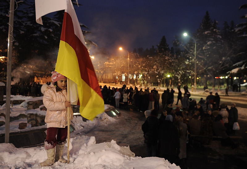 A girl holding the South Ossetia&#039;s flag in the central square of Tskhinvali