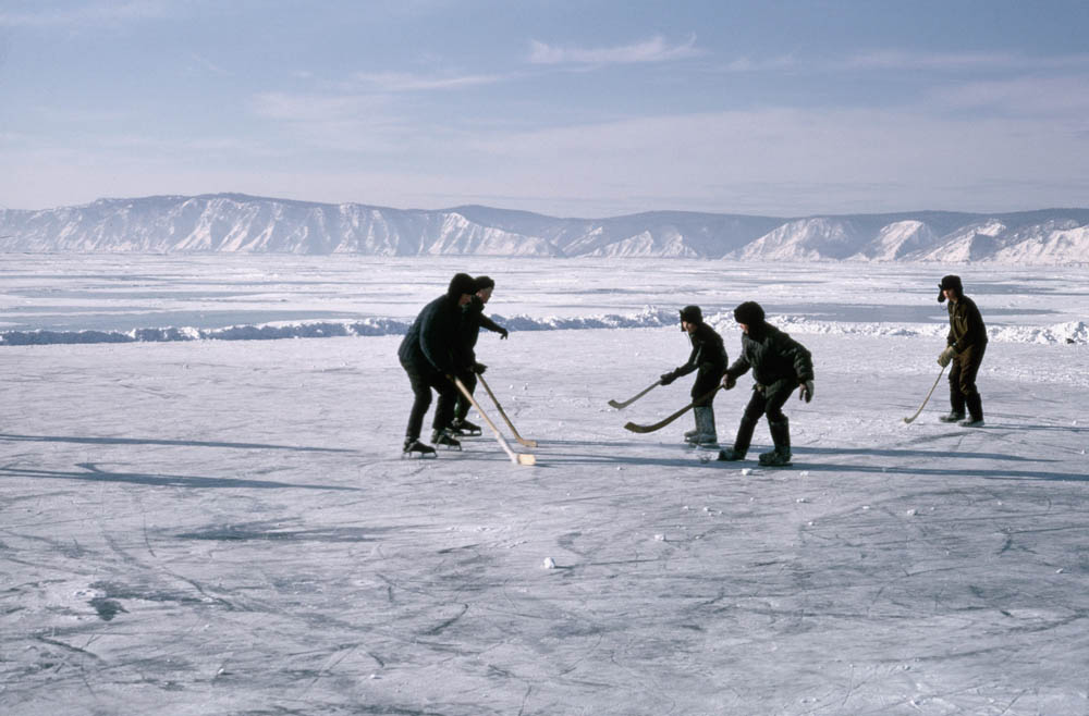Boys play hockey on a frozen part of Lake Baikal which they have cleared of snow.