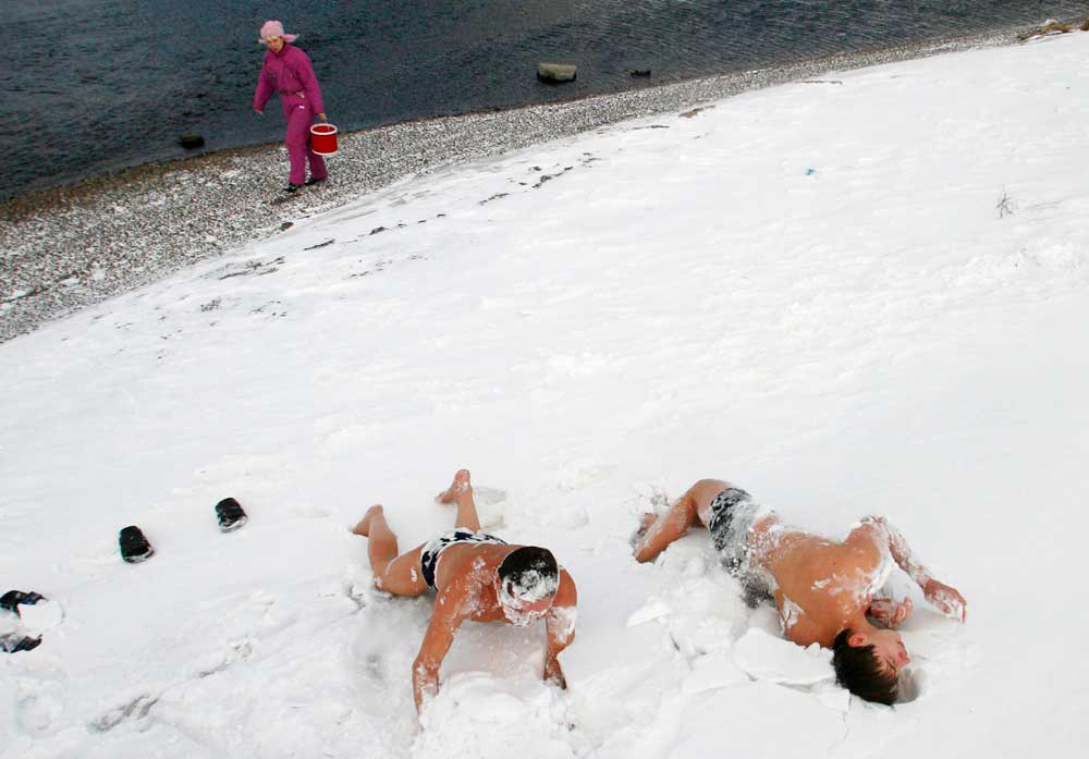 16/21. Чланови локалног клуба љубитеља зимског пливања ваљају се у снегу у сибирском граду Краснојарску после купања у Јенисеју.