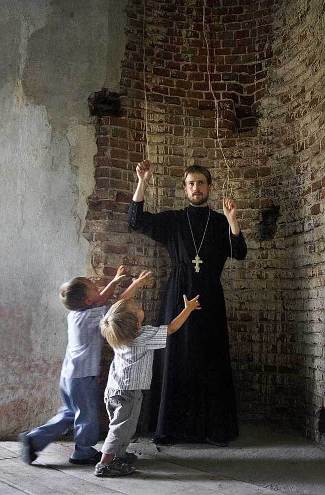 Le prêtre Sergueï Smirnov dans l'une des églises rurales de la région de Voronej. Ses fils accourent au son des cloches de l'église. Ecolier et étudiant en économie, le père Sergueï a souvent visité des monastères avec son père. Ces voyages, ainsi que le contact qu'il a eu avec les moines, a influencé la décision de Sergueï d'entrer au Séminaire théologique orthodoxe de Voronej après l'obtention de son diplôme. Il est actuellement membre du clergé du diocèse de Voronej.