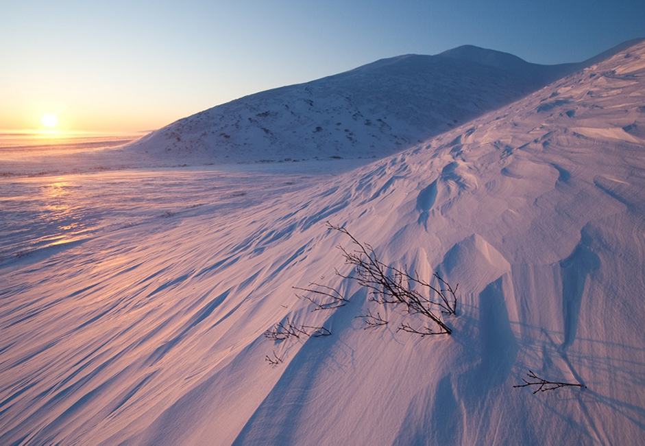 Chukotka dilingkupi malam Arktik yang panjang ketika sinar matahari hanya terlihat beberapa jam saja dalam sehari. // Malam putih di Teluk St Lawrence Bay (Laut Bering). Masih ada potongan-potongan salju dan es pada akhir Juni.