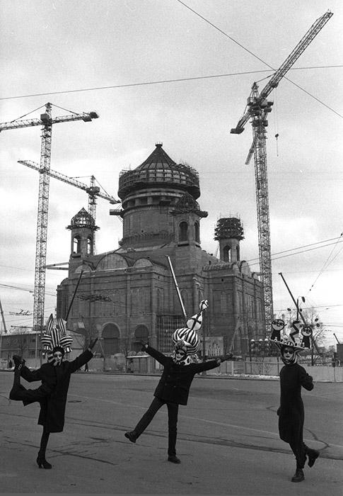 「モスクワ物語：20世紀」は、モスクワのトップ写真家50人による280枚の写真からなる。ストリート写真、都市景観や建築写真で名の通った巨匠による作品が集められた。// 「建築工事現場の前で踊る」、1996年。救世主ハリストス大聖堂の再建工事現場前。