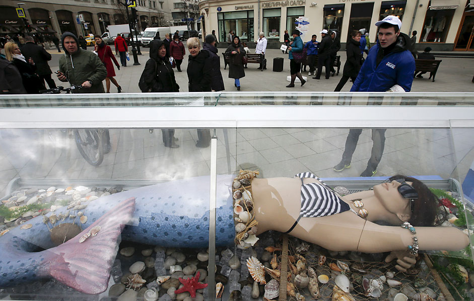 People look at a dummy of a seamaid which is on display near a streetfish market in central Moscow.