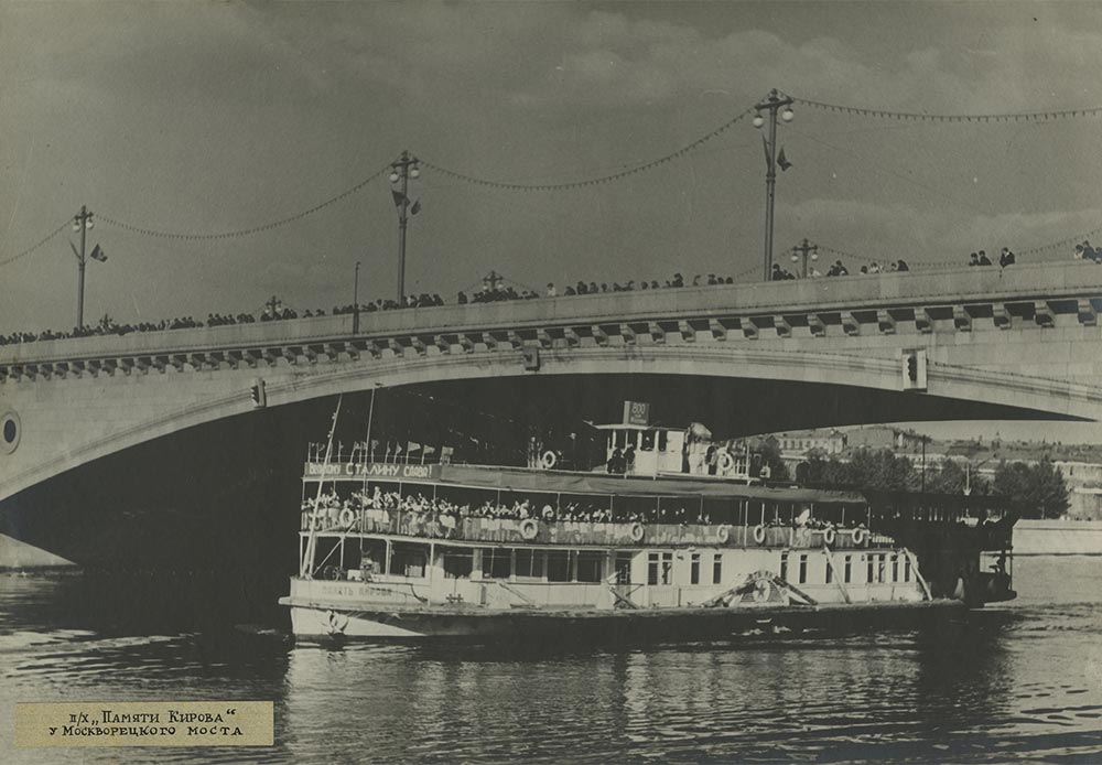 Dieses Foto aus den 1930er Jahren zeigt ein Schiff namens „Kirow“ (Kirow war ein Sozialrevolutionär, der 1934 starb). Das Schiff fuhr mit einer Fahne an der Mastspitze, auf der zu lesen war „Ehre dem großen Stalin“, den Fluss Moskwa herunter und durch die große Moskwa-Brücke.