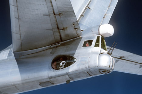 A radio-gunner in the Tu-95 Bear strategic bomber cockpit, photographed from an F4D Phantom fighter of the U.S. Air Force