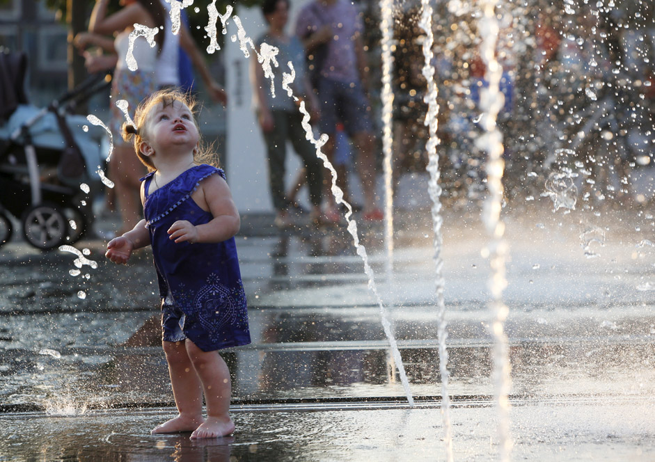 Дете играе в фонтана в парка „Горки” през горещия ден.