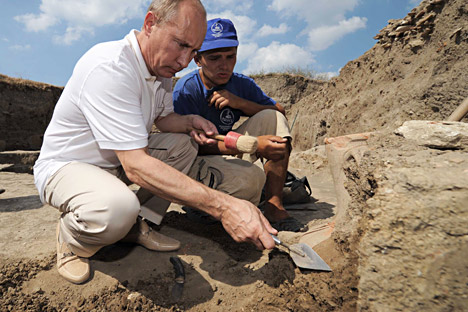 2011年8月10日、タマン半島。ウラジーミル・プーチン首相（左）が、古代ギリシャの都市ファナゴリアの発掘調査を行った考古学者のキャンプで、アンフォラをきれいにする。＝