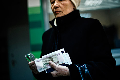 Возрасна жена со руски банкноти во рацете.