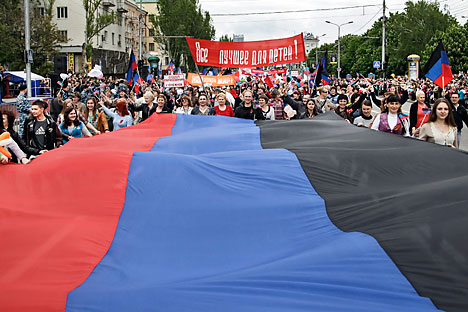 Local citizens carry a giant flag of the self-proclaimed Donetsk People's Republic (DNR or DPR) during their march marking the first anniversary of the referendum in downtown Donetsk, 11 May 2015.