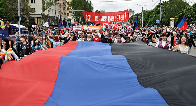 Des habitants locaux portent le drapeau de la République populaire autoproclamée de Donetsk (DNR) lors d’une marche à l’occasion du premier anniversaire du référendum tenu le 11 mai 2014 et qui a donné naissance à la DNR.