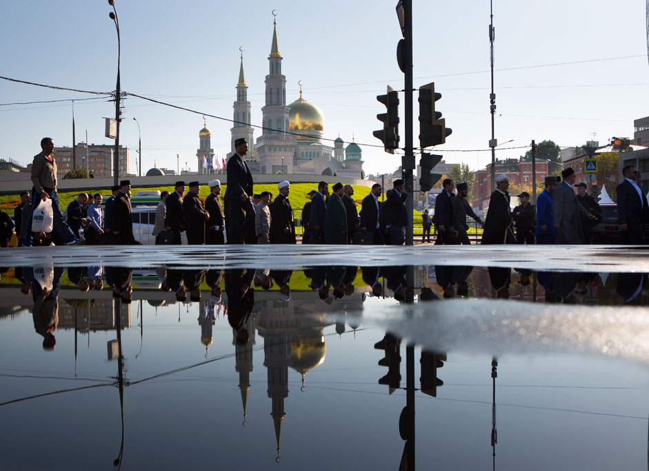 Believers head to the main mosque reflected in pool water in Moscow, Russia, early morning Wednesday, Sept. 23, 2015. Joined by the Turkish and Palestinian leaders, Russian President Vladimir Putin on Wednesday ceremoniously opened Moscow’s new main mosque and spoke of the need to teach traditional Islamic values to young Russian Muslims.
