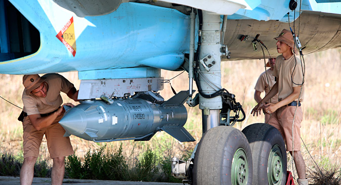 In this photo taken on Saturday, Oct. 3, 2015, Russian military support crew attach a satellite guided bomb to SU-34 jet fighter at Hmeimim airbase in Syria. Russia has insisted that the airstrikes that began Wednesday are targeting the Islamic State group and al-Qaida's Syrian affiliates, but at least some of the strikes appear to have hit Western-backed rebel factions