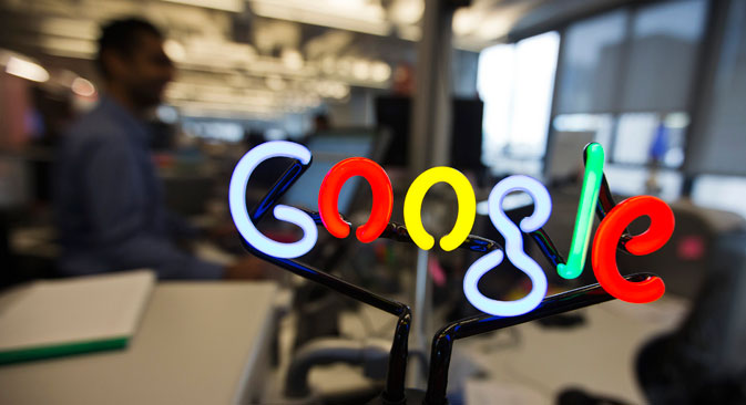A neon Google logo is seen as employees work at the new Google office in Toronto, November 13, 2012