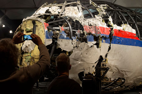 Para wartawan mengambil gambar puing-puing badan pesawat MH-17 yang telah direkonstruksi setelah presentasi laporan akhir Dewan Keselamatan Belanda atas apa yang menyebabkan kecelakaan pesawat Malaysia Airlines di atas langit Ukraina pada 2014 lalu.