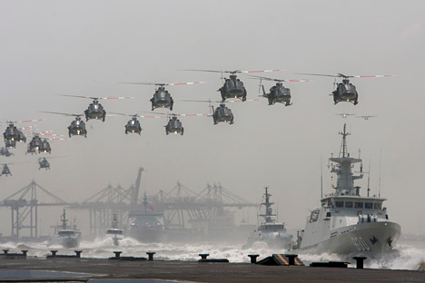 Helikopter AU Indonesia membentuk formasi di atas kapal AL Indonesia yang berlayar selama perayaan hari Angkatan Bersenjata ke-69 yang dipimpim oleh Presiden Susilo Bambang Yudhoyono di kota Surabaya, 7 Oktober 2014.