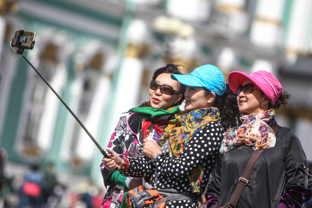 Chinese tourists taking a selfie in front of the Hermitage, St. Petersburg.