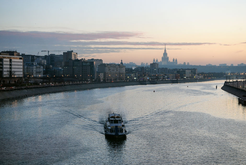 Barco navega por el río Moscova con la Universidad Estatal de Moscú al fondo.
