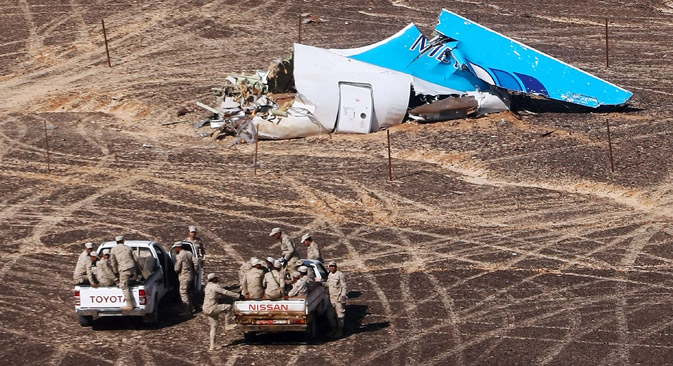 In this photo made available Monday, Nov. 2, 2015, and provided by Russian Emergency Situations Ministry, Egyptian Military on cars approach a plane's tail at the wreckage of a passenger jet bound for St. Petersburg in Russia that crashed in Hassana, Egypt, on Sunday, Nov. 1, 2015. The Russian cargo plane on Monday brought the first bodies of Russian victims killed in a plane crash in Egypt home to St. Petersburg, a city awash in grief for its missing residents. 