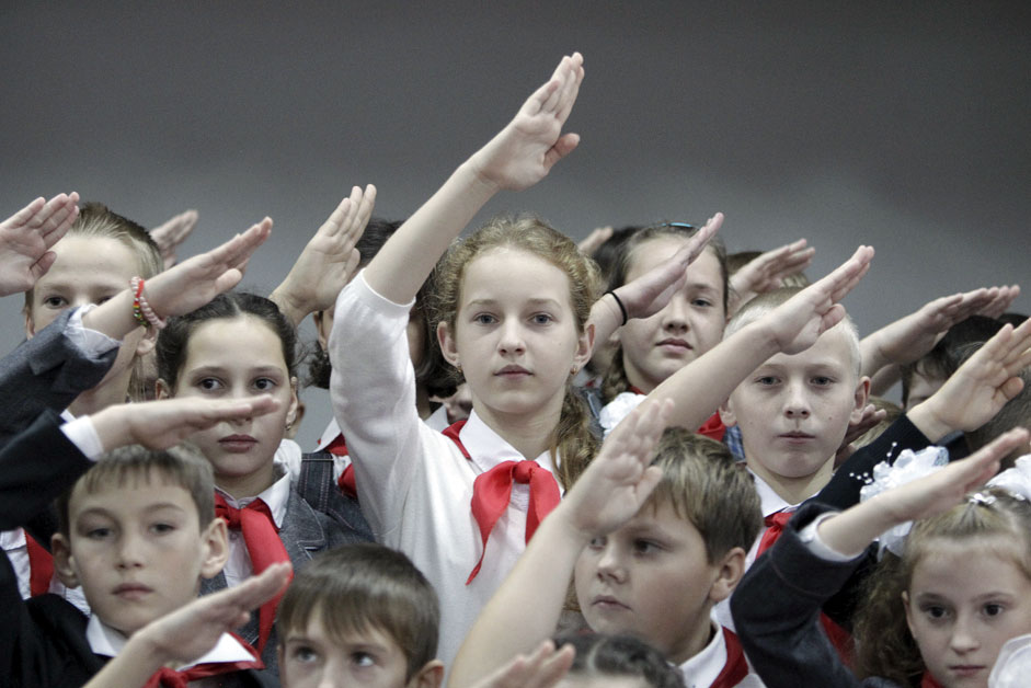 Junge Pioniere mit roten Halstüchern begrüßen die neuen Mitglieder ihrer Organisation in der Schule von Kazminskoje, Region Stawropol. 