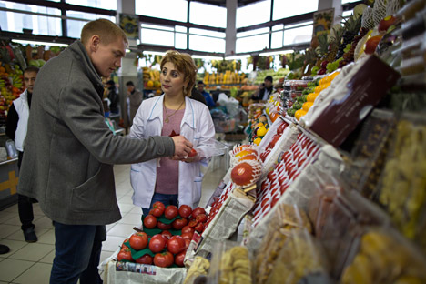 Un homme achète des tomates au marché Dorogomilovski à Moscou. 