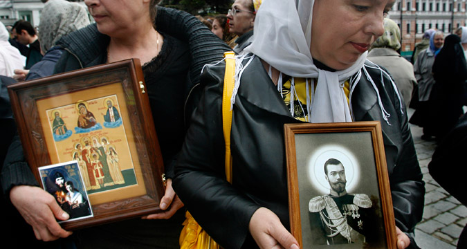 Women hold icons depicting the last Russian Czar Nicholas II