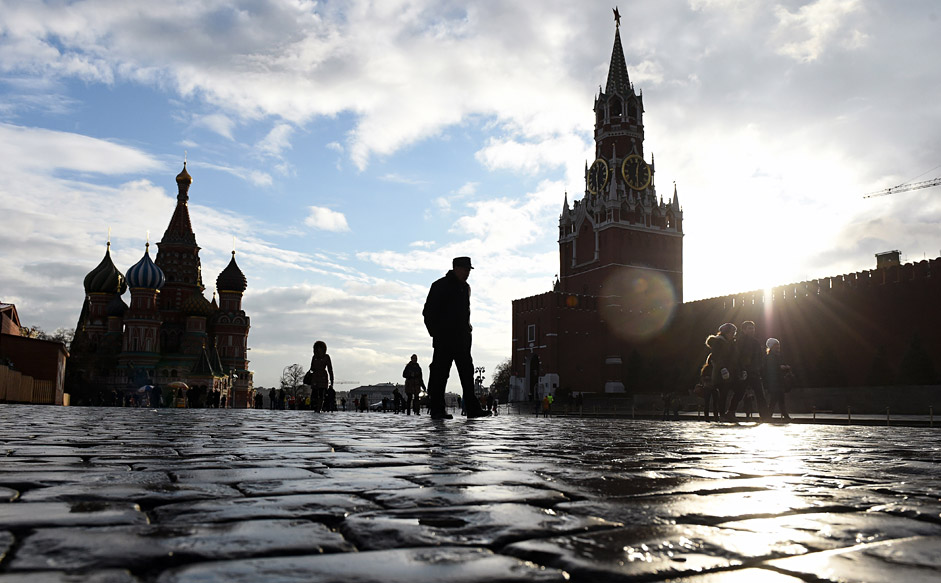 People walk across Red Square, with the Kremlin's Spasskaya (Saviour) Tower (R) and St. Basil's Cathedral (L) seen in the background, in central Moscow on December 22, 2015. The temperatures in the Russian capital reached today 6 C (42 F). 
